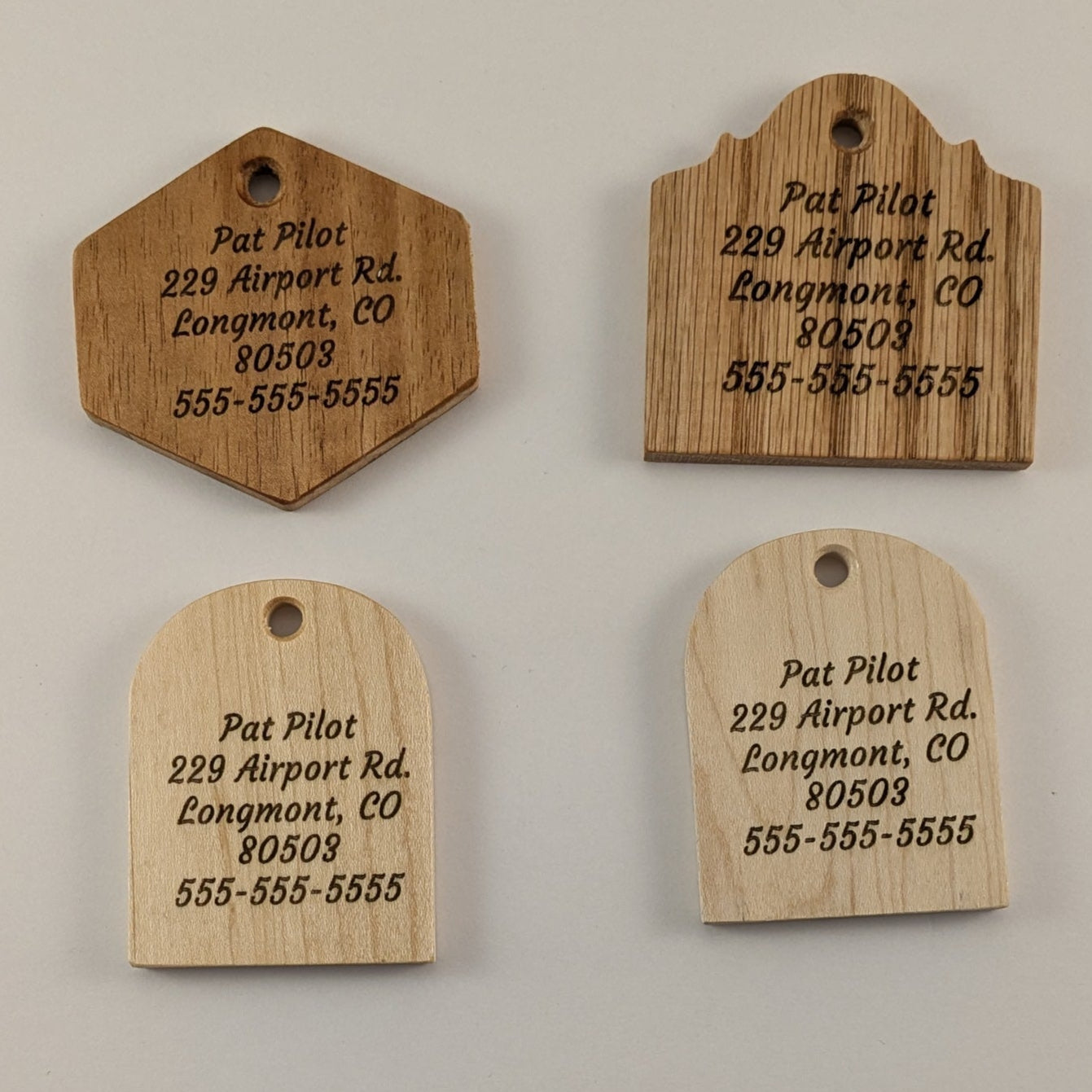 Four wooden tags with engraved contact information